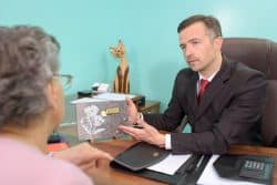 Funeral director sitting across the desk from woman.