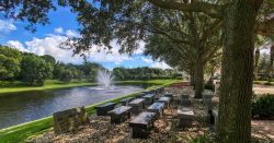 Benches in front of a stone memorial monument overlooking the water.